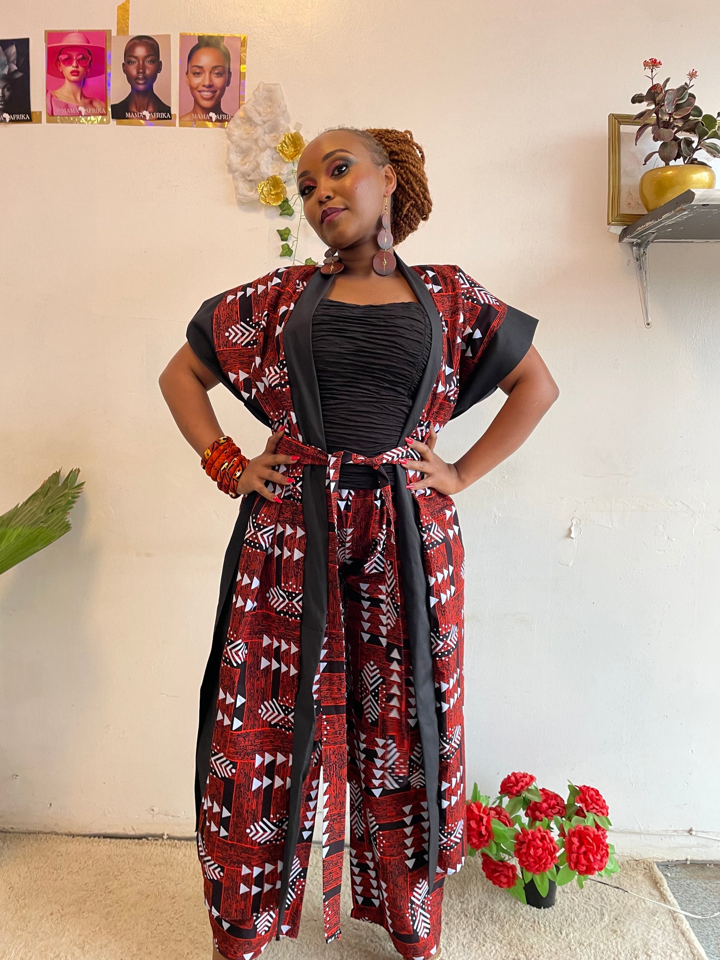 Woman wearing a red and black patterned dress in an indoor setting with decorative elements.